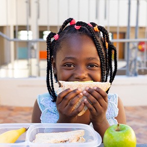 Child smiling while eating lunch at school