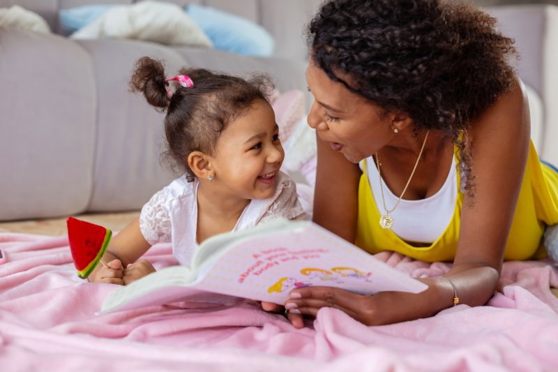Parent smiling with child after tooth extraction
