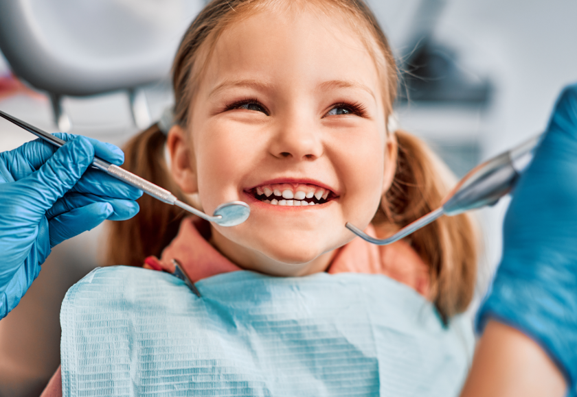 Little girl in dental chair, smiling