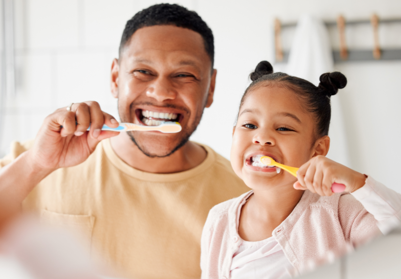 Father and daughter brushing teeth